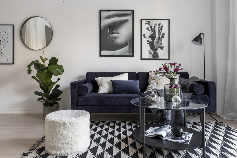 Photo of a medium sized scandi enclosed living room in Stockholm with white walls, light hardwood flooring and grey floors.