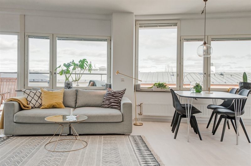 Photo of a medium sized scandi formal open plan living room in Stockholm with white walls, light hardwood flooring, no fireplace, a concrete fireplace surround, a wall mounted tv and white floors.