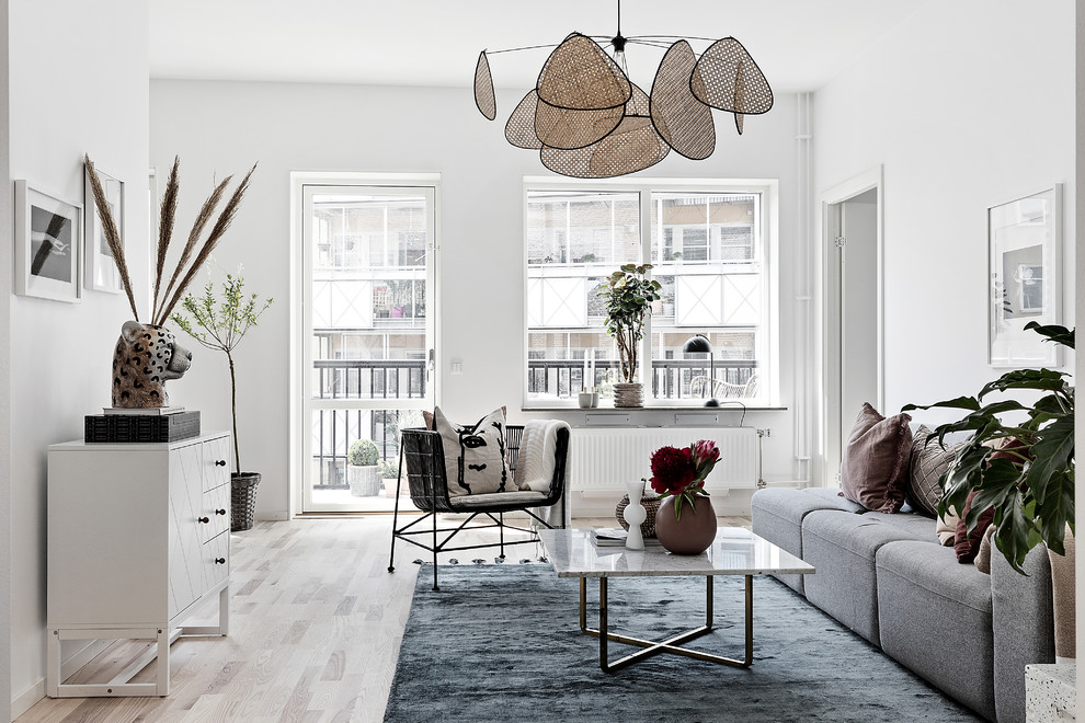 Inspiration för ett minimalistiskt vardagsrum, med vita väggar, ljust trägolv och beiget golv