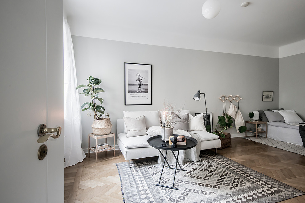 Foto de salón abierto nórdico de tamaño medio con paredes grises y suelo de madera en tonos medios