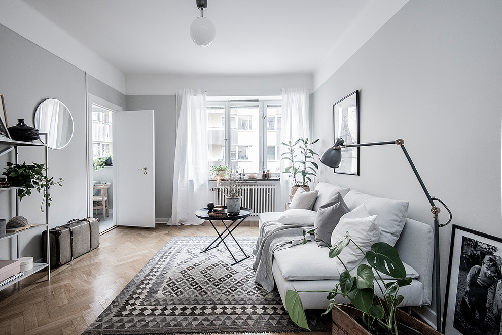 Mittelgroßes, Abgetrenntes Skandinavisches Wohnzimmer ohne Kamin mit grauer Wandfarbe, braunem Holzboden und braunem Boden in Stockholm