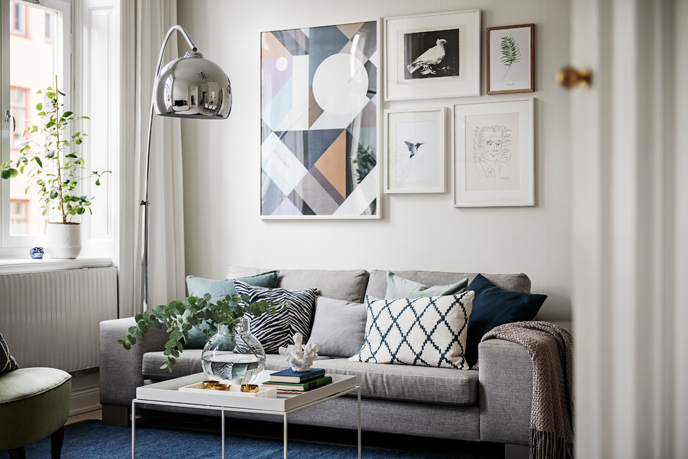 Idéer för ett minimalistiskt vardagsrum, med vita väggar, ljust trägolv och beiget golv