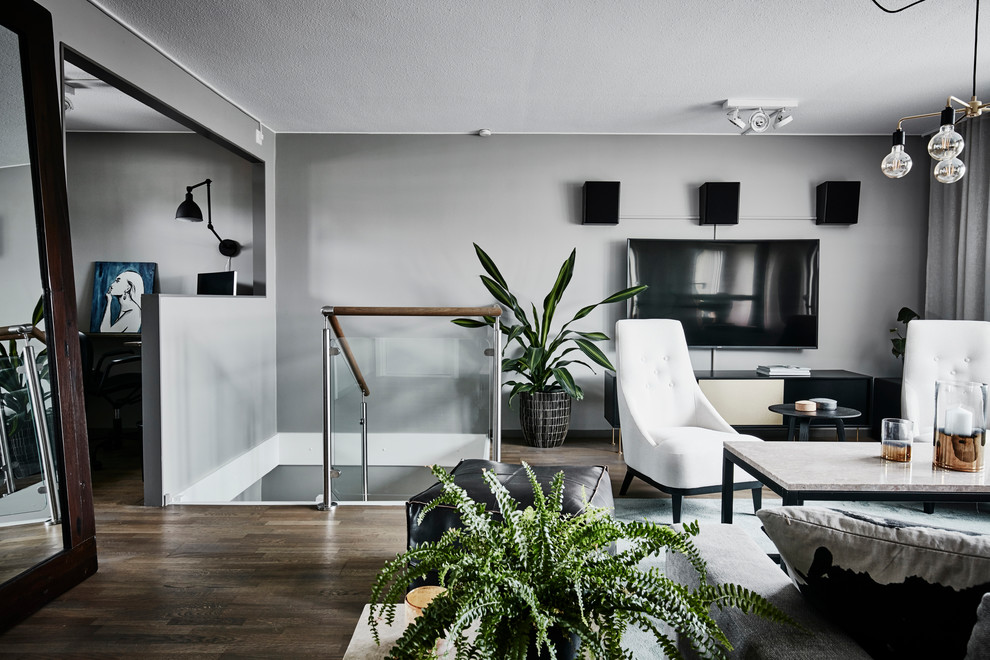 Inspiration för stora moderna separata vardagsrum, med grå väggar, mellanmörkt trägolv, en väggmonterad TV och brunt golv