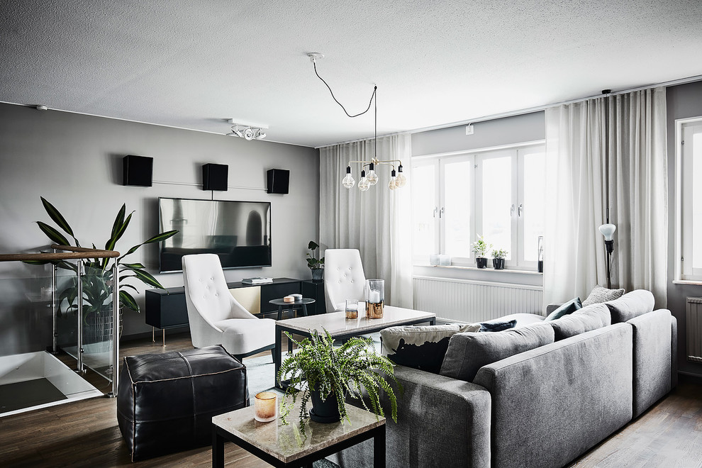 Ejemplo de salón para visitas abierto escandinavo de tamaño medio sin chimenea y televisor con paredes grises, suelo de madera oscura y suelo marrón