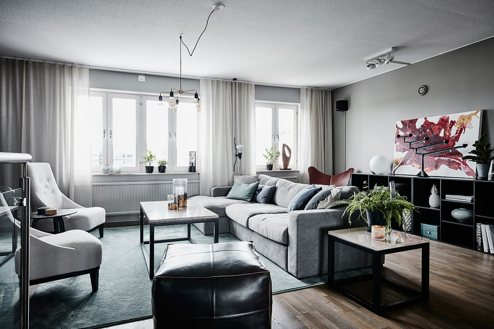 Пример оригинального дизайна: парадная, открытая гостиная комната среднего размера в скандинавском стиле с серыми стенами, темным паркетным полом и коричневым полом без камина, телевизора