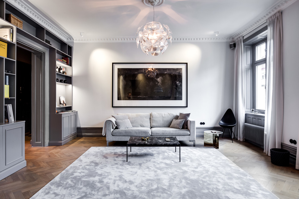 This is an example of a large scandinavian formal enclosed living room in Stockholm with white walls, medium hardwood flooring, no fireplace and brown floors.