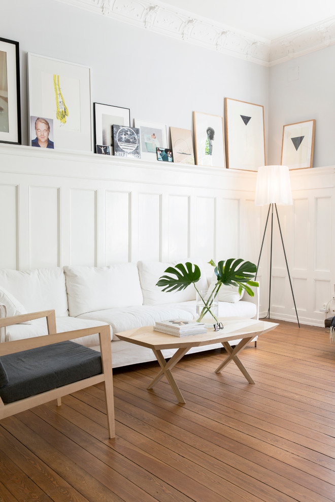Mid-sized danish open concept and formal light wood floor living room photo in Gothenburg with white walls and no tv