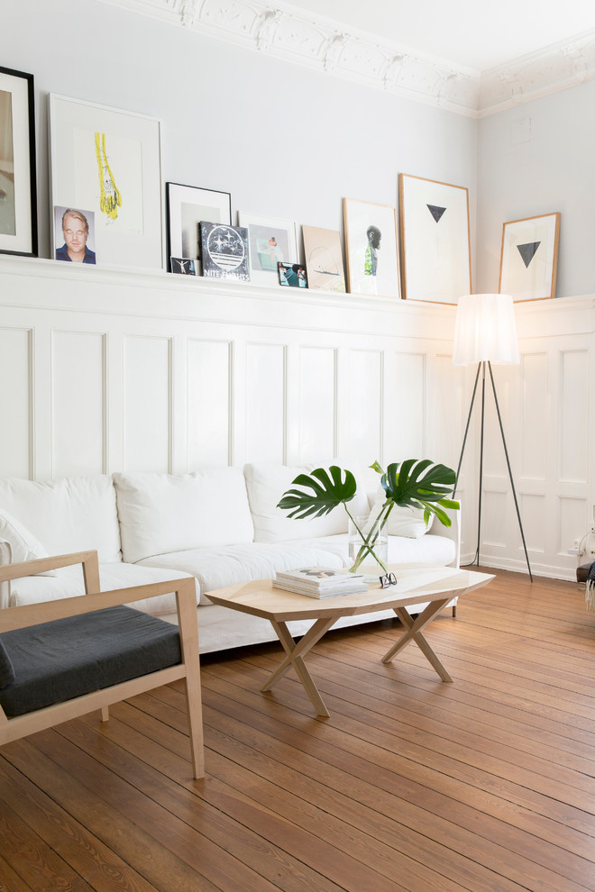 Idéer för mellanstora minimalistiska allrum med öppen planlösning, med vita väggar, ljust trägolv och ett finrum