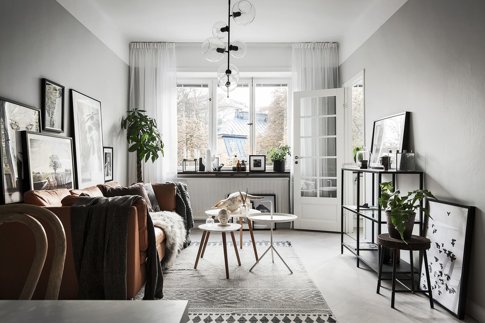 Nordisk inredning av ett mellanstort separat vardagsrum, med grå väggar, ljust trägolv och ett finrum