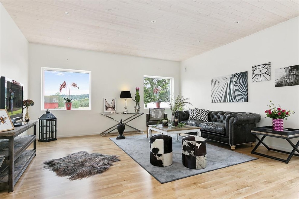 Foto di un grande soggiorno boho chic aperto con pareti bianche, parquet chiaro, TV autoportante, sala formale e nessun camino