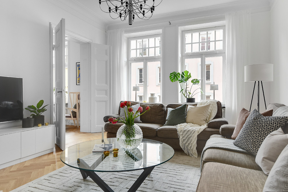 Foto de salón cerrado nórdico de tamaño medio con paredes blancas, suelo de madera clara y televisor independiente