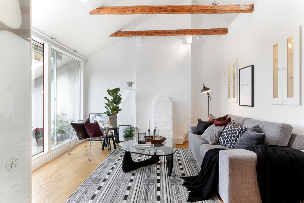 Medium sized scandinavian formal enclosed living room in Stockholm with white walls, light hardwood flooring and no tv.
