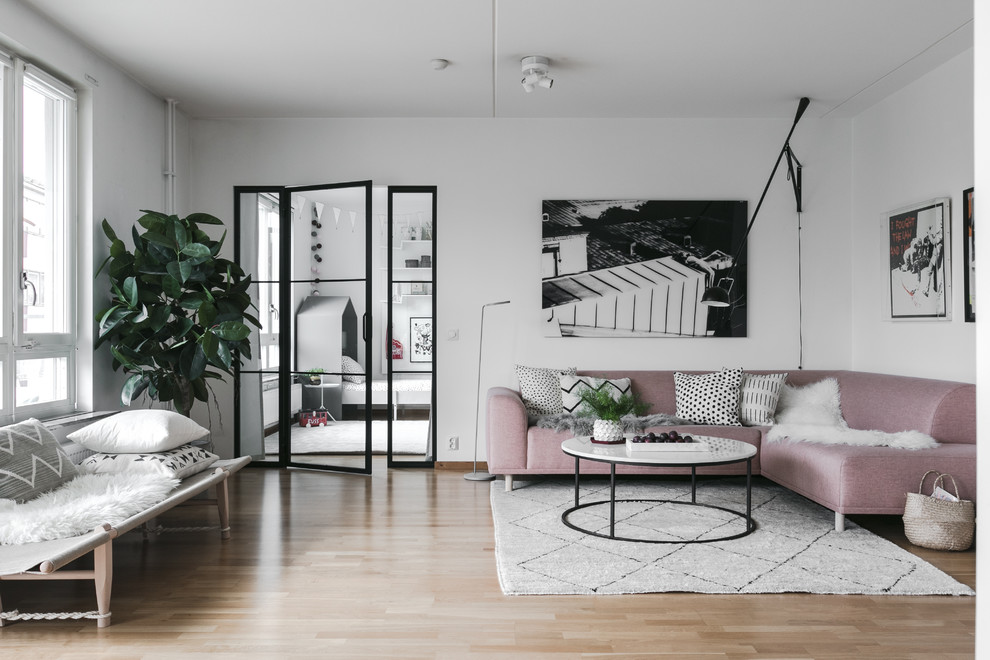 На фото: гостиная комната среднего размера в скандинавском стиле с белыми стенами, паркетным полом среднего тона и бежевым полом с