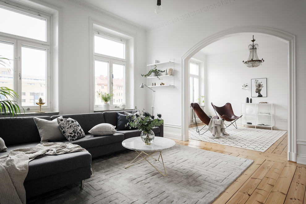 Inspiration pour un grand salon nordique ouvert avec une salle de réception, un mur blanc et un sol en bois brun.