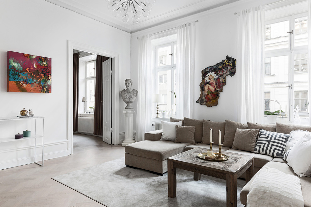 Inspiration för minimalistiska vardagsrum, med vita väggar och ljust trägolv