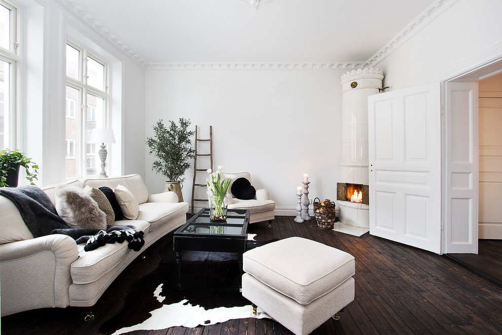 マルメにあるラグジュアリーな北欧スタイルのおしゃれなリビング (白い壁、濃色無垢フローリング、コーナー設置型暖炉、テレビなし) の写真