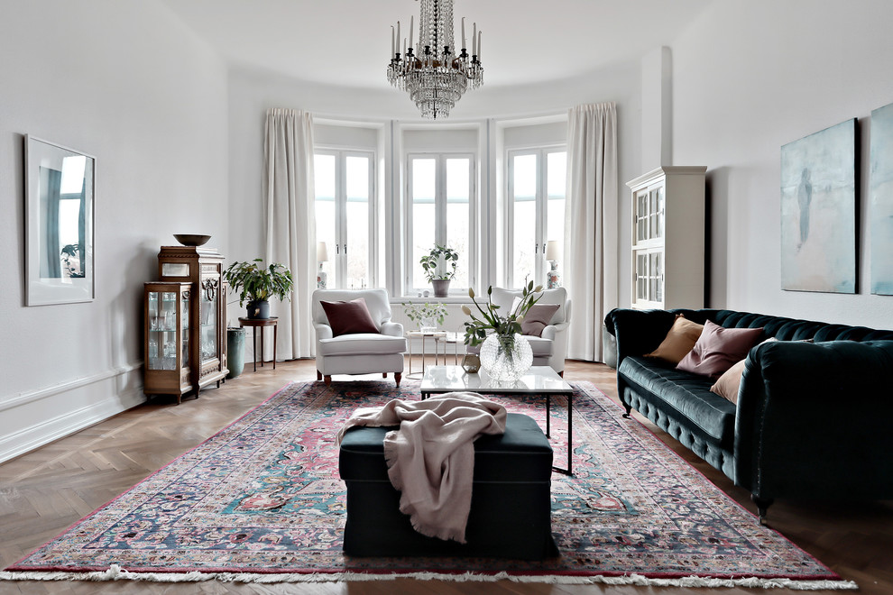 This is an example of a large scandinavian formal enclosed living room in Gothenburg with white walls, medium hardwood flooring and brown floors.