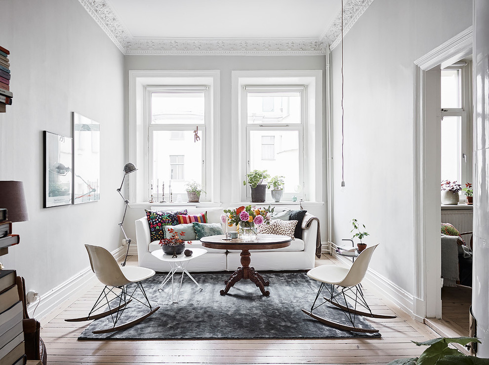 Skandinavisches Wohnzimmer mit weißer Wandfarbe und braunem Holzboden in Göteborg