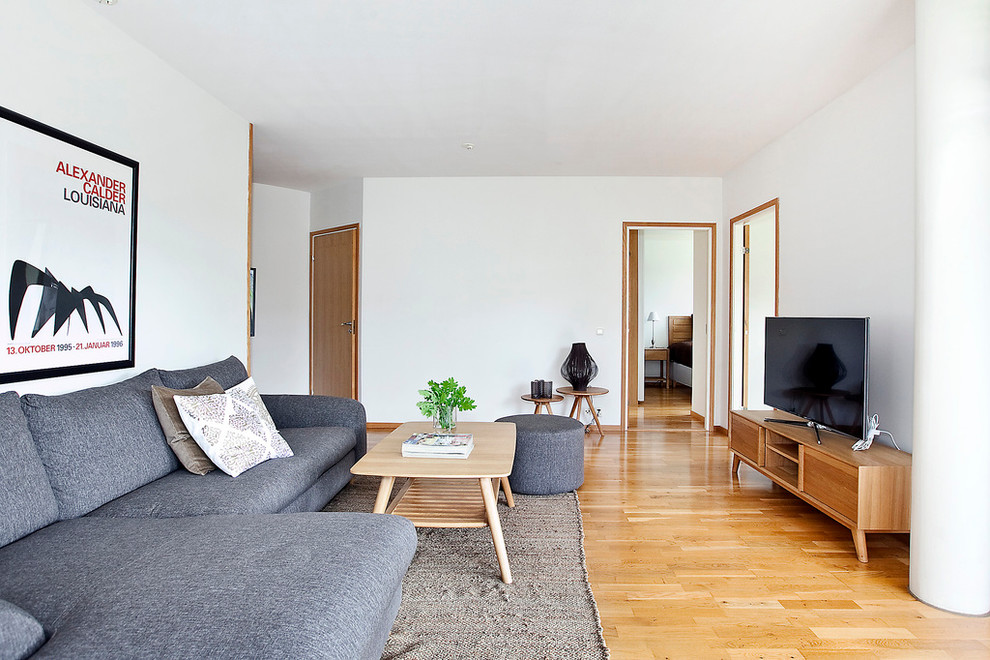 Großes, Repräsentatives, Offenes Nordisches Wohnzimmer ohne Kamin mit weißer Wandfarbe, hellem Holzboden und freistehendem TV in Malmö