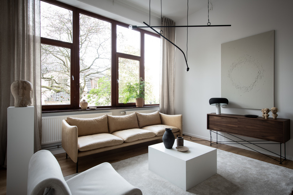 Bild på ett skandinaviskt vardagsrum, med ett finrum, vita väggar och mörkt trägolv