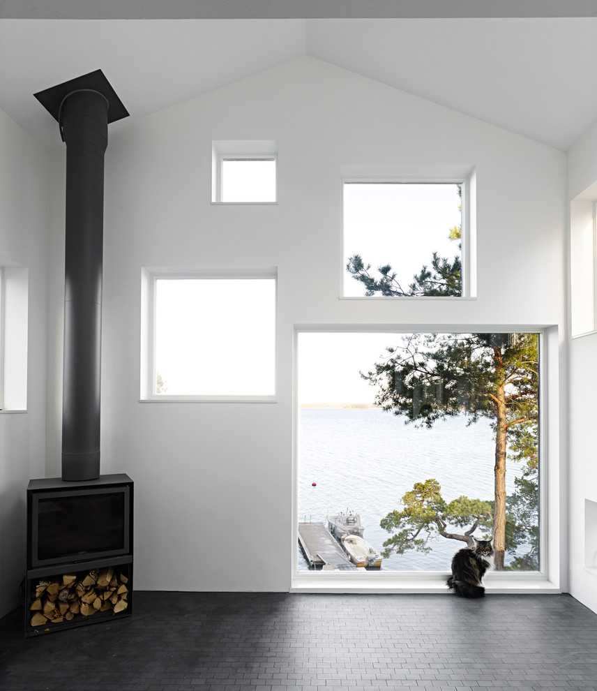 Diseño de salón para visitas abierto escandinavo grande sin televisor con paredes blancas, suelo de pizarra y estufa de leña