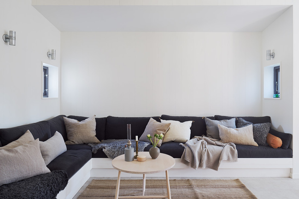 Mittelgroßes, Fernseherloses, Abgetrenntes Nordisches Wohnzimmer ohne Kamin mit weißer Wandfarbe und Betonboden in Stockholm