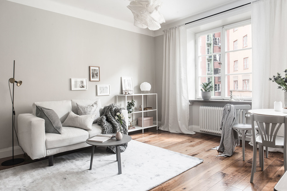 Inspiration for a scandinavian open concept medium tone wood floor living room remodel in Stockholm with gray walls