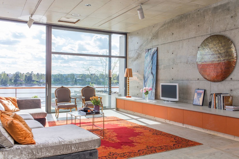 Foto di un grande soggiorno minimalista aperto con sala formale, pareti grigie, pavimento in cemento, nessun camino e nessuna TV