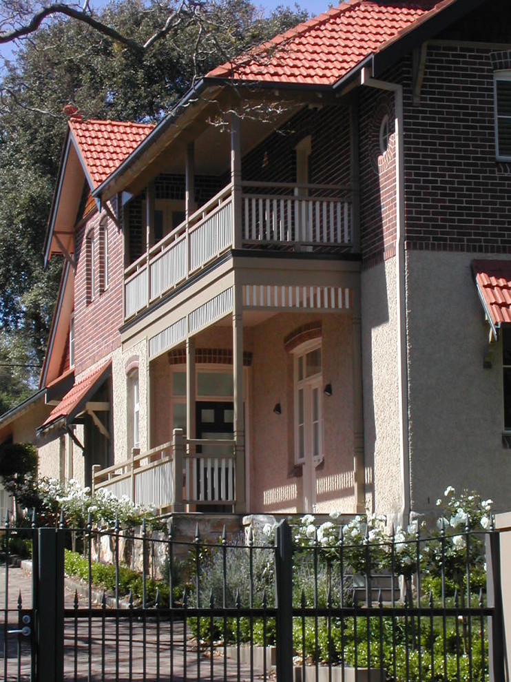 Idee per un grande portico tradizionale davanti casa con pavimentazioni in mattoni e un tetto a sbalzo