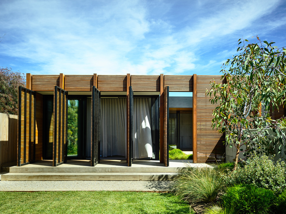 Cette image montre un porche d'entrée de maison design avec une dalle de béton.