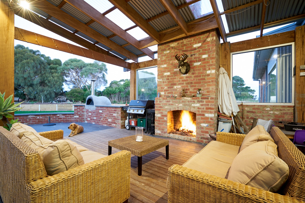 Idée de décoration pour un porche d'entrée de maison arrière chalet de taille moyenne avec un foyer extérieur, une terrasse en bois et une pergola.