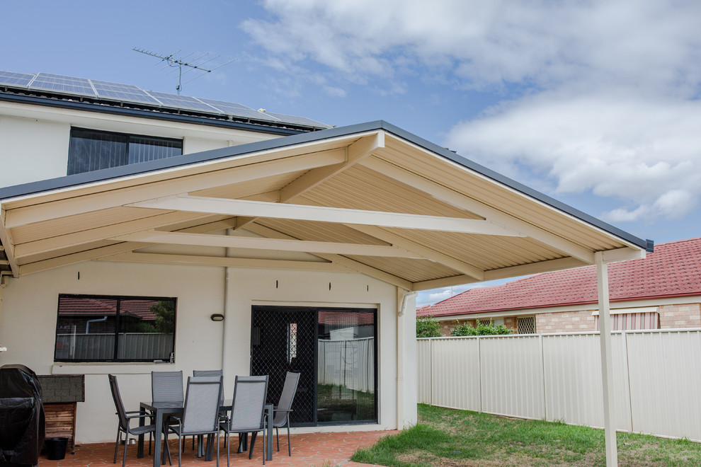 Cette photo montre un porche d'entrée de maison arrière tendance avec une extension de toiture.