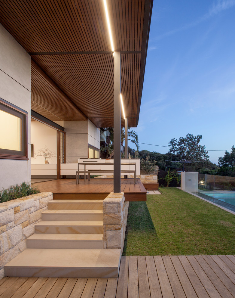 Idée de décoration pour un grand porche d'entrée de maison arrière design avec une terrasse en bois.