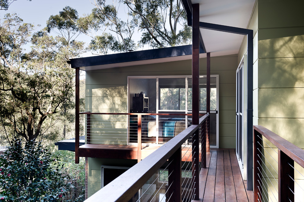 Inspiration pour un grand porche d'entrée de maison latéral design avec une terrasse en bois et une extension de toiture.