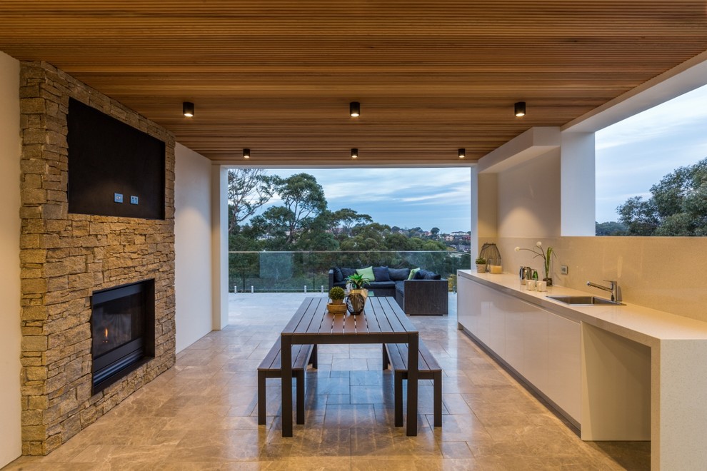 Large minimalist stone back porch photo in Sydney with a fire pit