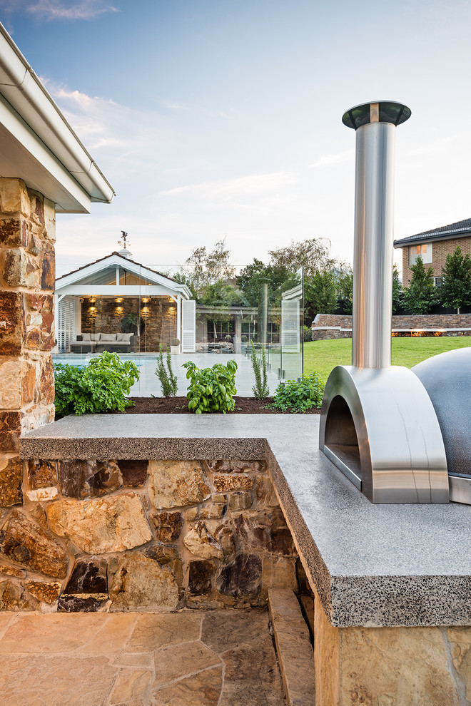 Geräumige Urige Veranda hinter dem Haus mit Outdoor-Küche und Natursteinplatten in Melbourne
