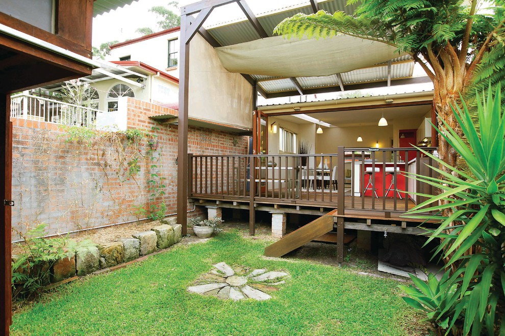 Inspiration pour un porche d'entrée de maison design de taille moyenne avec une terrasse en bois et un auvent.