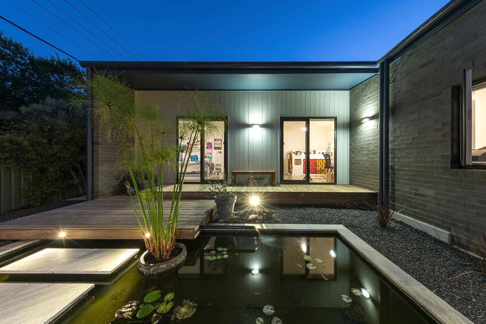 Kleine Moderne Veranda hinter dem Haus mit Wasserspiel und Dielen in Canberra - Queanbeyan