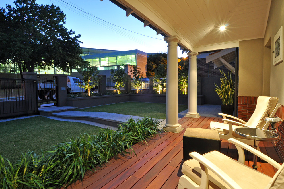 Réalisation d'un porche d'entrée de maison avant tradition de taille moyenne avec une terrasse en bois et une extension de toiture.