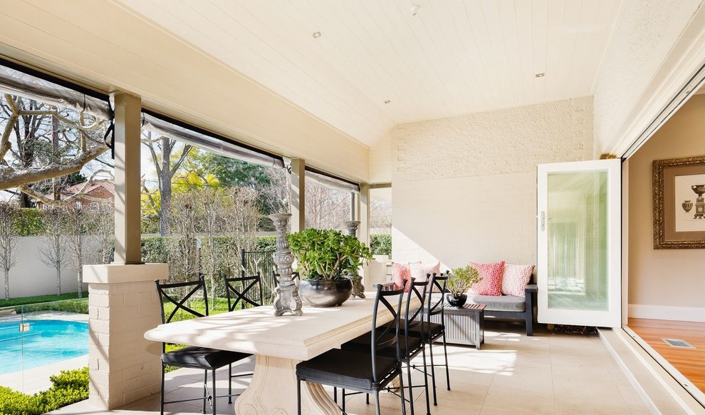 Inspiration pour un grand porche d'entrée de maison latéral traditionnel avec des pavés en pierre naturelle et une extension de toiture.