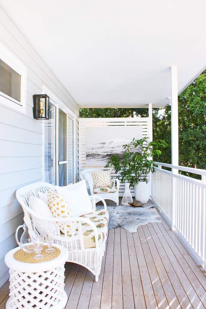 Small beach style screened-in back porch idea in Sydney with decking and a roof extension