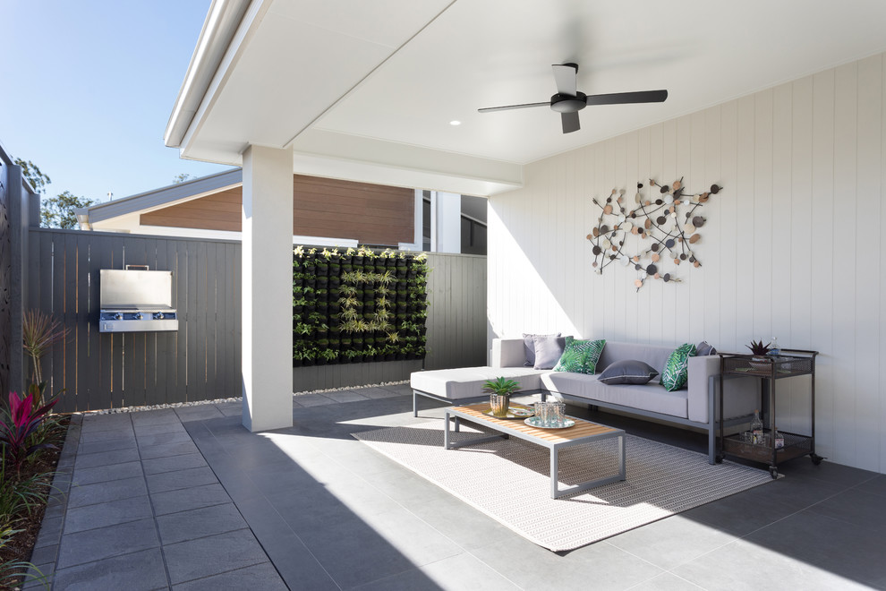 Идея дизайна: веранда на заднем дворе в современном стиле с вертикальным садом, покрытием из бетонных плит и навесом