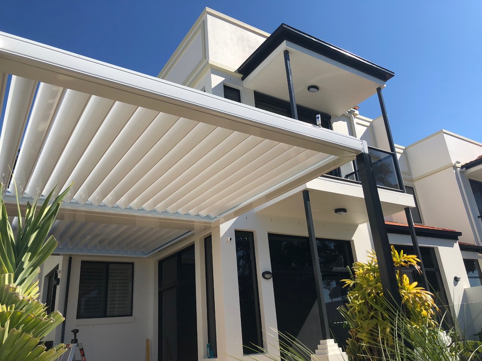 This is an example of a medium sized contemporary back veranda in Gold Coast - Tweed with stamped concrete and a pergola.