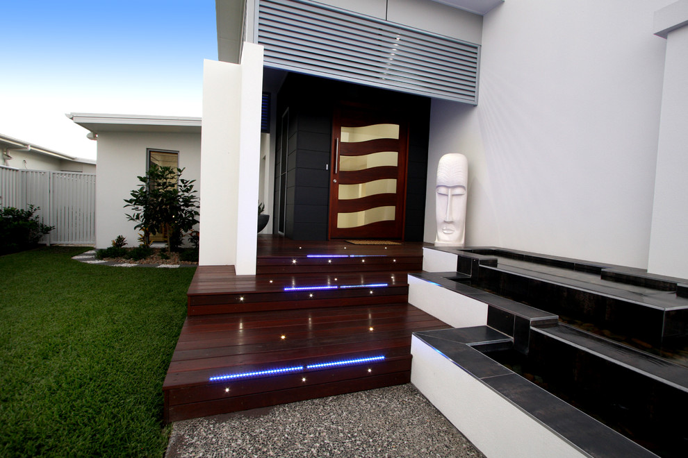 Modelo de terraza minimalista de tamaño medio en patio delantero y anexo de casas con fuente y entablado