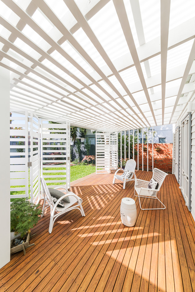 This is an example of a small contemporary back screened veranda in Melbourne with decking and a roof extension.