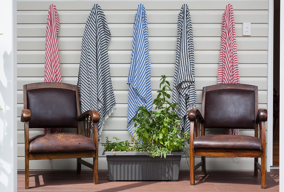 Idée de décoration pour un porche avec des plantes en pot tradition avec une terrasse en bois.