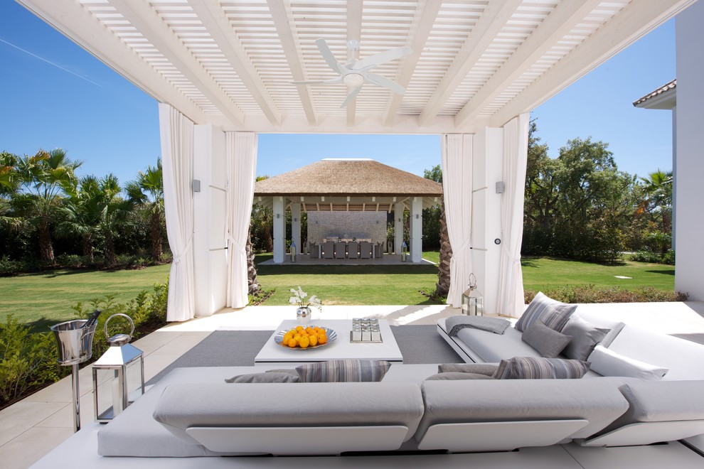 This is an example of a large mediterranean side veranda in Other with tiled flooring and a pergola.