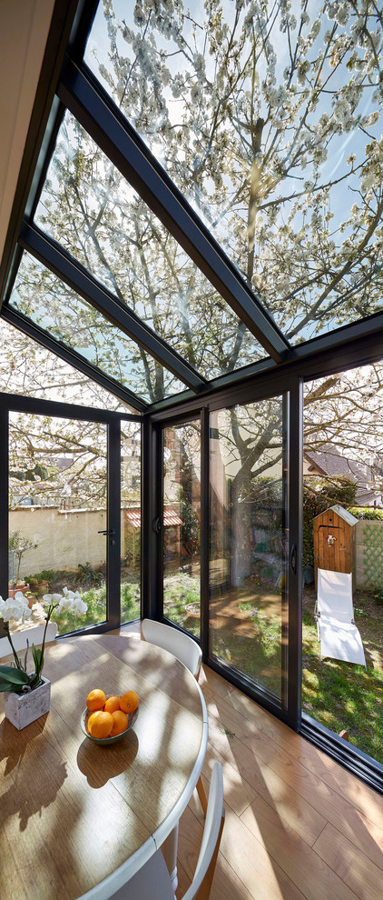 Foto di una piccola veranda minimal con parquet chiaro e soffitto in vetro