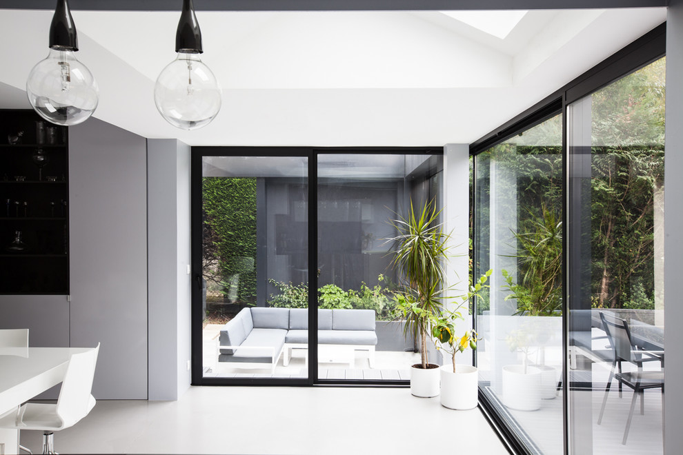 This is an example of a medium sized contemporary conservatory in Paris with concrete flooring, no fireplace and a skylight.