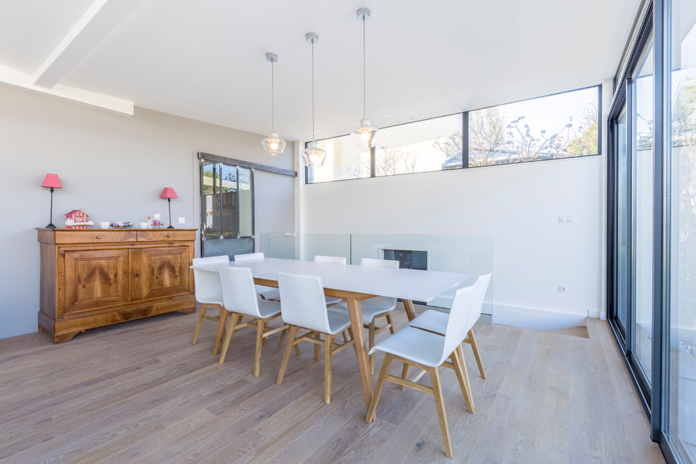 Réalisation d'une grande salle à manger design avec parquet clair et un sol beige.